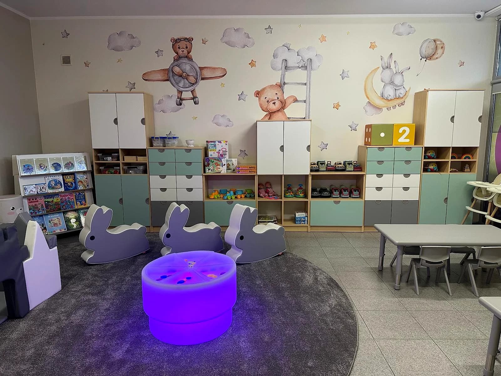 Sala z malowidłem misia na ścianie i wyspą sensoryczną