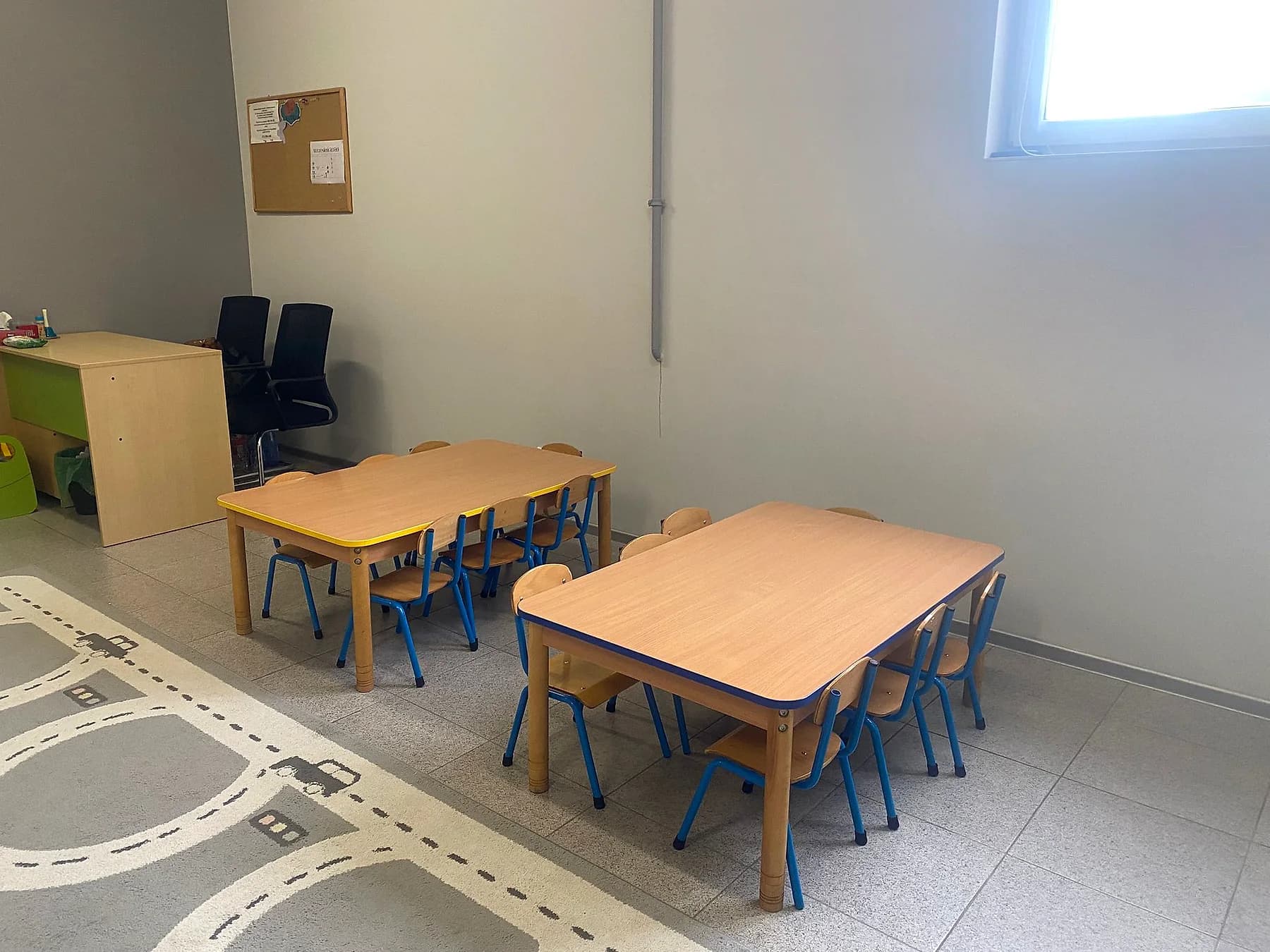Sala Kotków: stoliki i krzesełka dla dzieci na dywanie z drogą