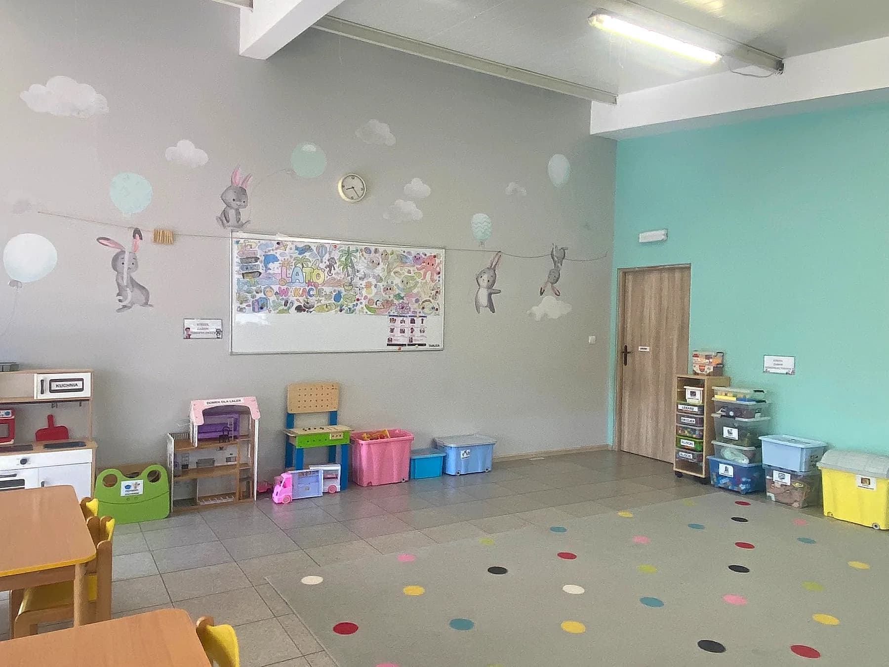 Ściana z zajączkami i balonami, kącik kuchenny i pojemniki na zabawki