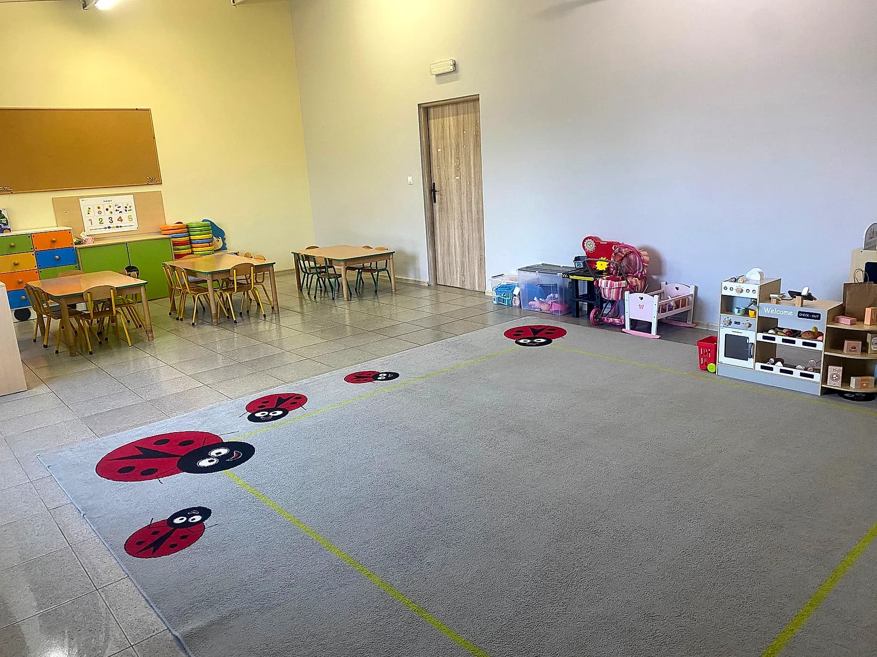 Sala Biedronek ze stolikami, tablicą i biedronkami na podłodze